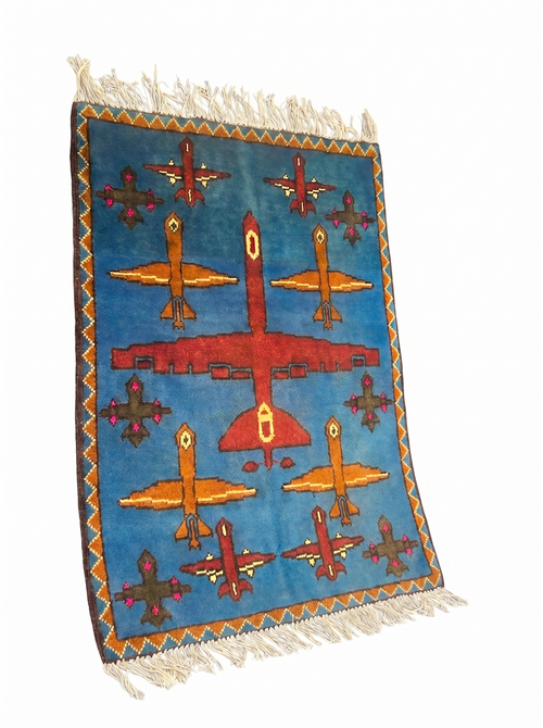 Drone Afghan war rug detail showing handmade wool weave and aircraft motifs