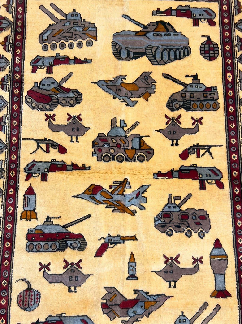 Soviet–Afghan war rug close-up showing handwoven military vehicle motifs