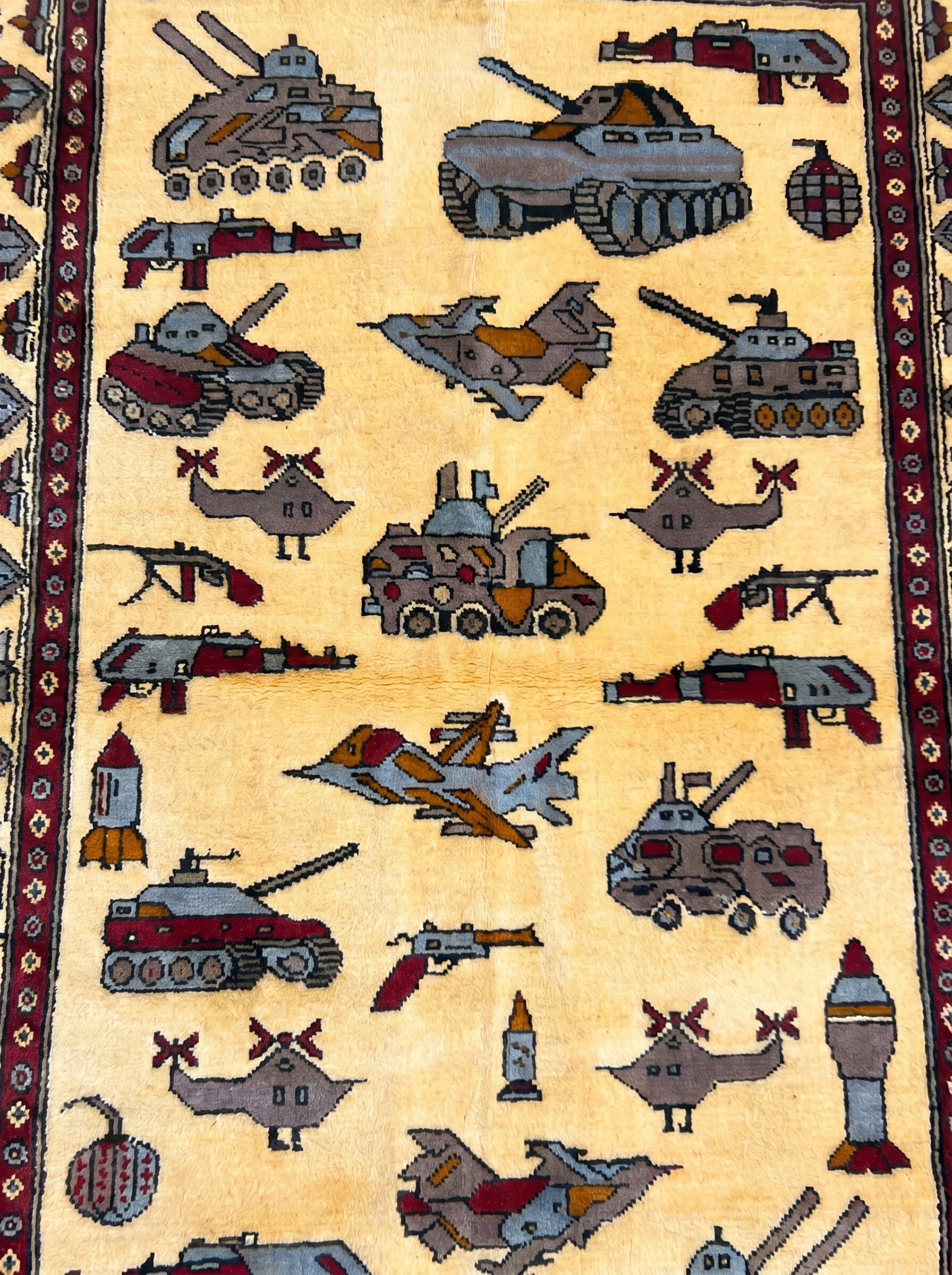Soviet–Afghan war rug close-up showing handwoven military vehicle motifs